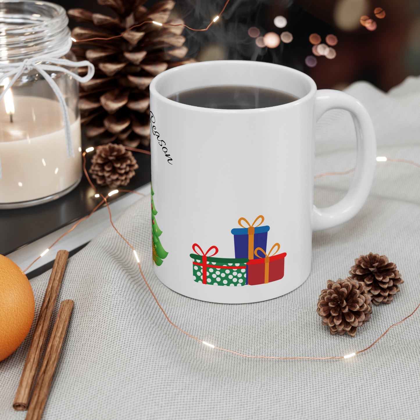 Christmas mug with baby Jesus, decorated tree, gifts, and “Jesus is the Reason” text