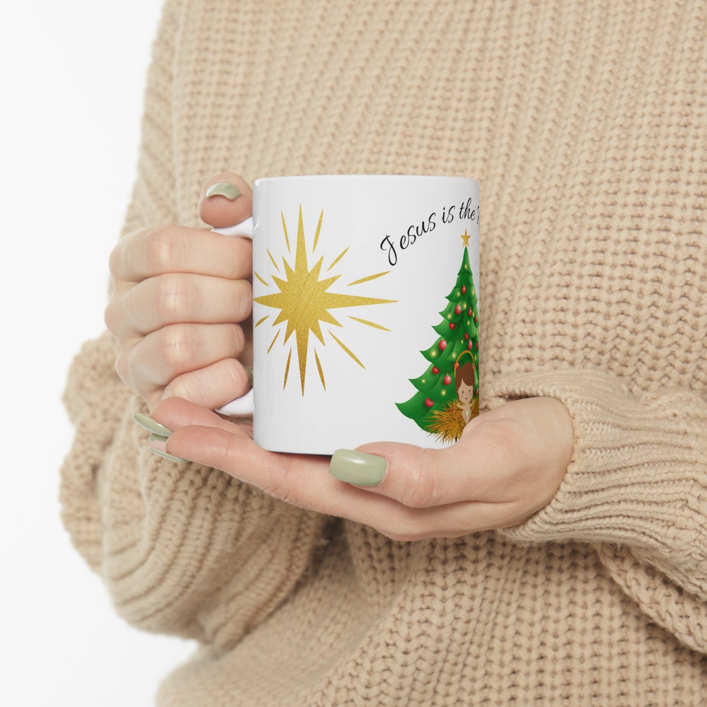 Christmas mug with baby Jesus, decorated tree, gifts, and “Jesus is the Reason” text